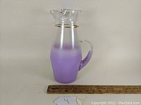 Side view of the purple gradient mid-century Blendo glass pitcher with clear handle and gold rim, shown next to a ruler for scale.
