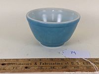 Front and slightly interior view of the blue Pyrex mixing bowl showing size and shape with ruler for scale.