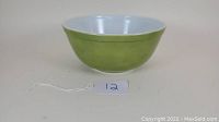 Side and top view of the vintage Pyrex verde green mixing bowl showing the smooth white interior and solid green exterior.