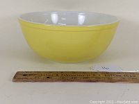 Side view of Pyrex 404 yellow mixing bowl showing shape and color.