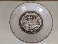 Top view showing central printed cheesecake recipe with decorative border around rim.