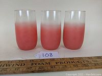 Front view of three salmon pink gradient tumblers lined up side by side.