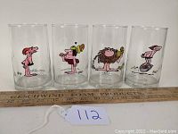 Four clear drinking glasses with colorful B.C. comic strip character illustrations in a row, identified by tag number 112, photographed front view.