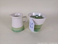 Creamer and sugar bowl with lid shown from front angle to display overall shape and pattern.