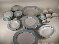 Full set including plates, bowls, cups, cream and sugar bowls, platters with seafoam green rims and pink leaf floral design with silver trimming