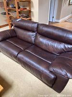 Front view of brown leather three-seat couch