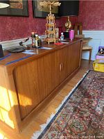 Front view of entire teak buffet with decorative items on top