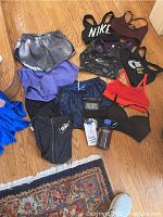 Photo of all apparel items including Nike shorts, sports bras from Nike and Lululemon, multiple colors and patterns with accompanying water bottle and packaging material.