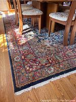 Rug placed under dining table showing overall pattern and color palette.