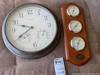 Acurite wall clock and Springfield weather station displayed together side-by-side on a soft surface.