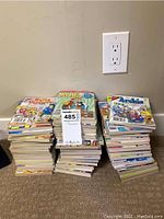 Three large stacks of assorted Archie Comics magazines including Archie, Betty and Veronica, and Jughead Double Digest magazines seen stacked on carpet against wall