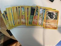 Front view of a spread of various Pokemon trading cards showing different Pokemon characters including Pupitar and Spinda.