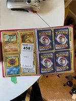 Open binder showing front sides of Pokémon character cards Machop, Sandslash, Cloyster