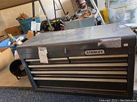 Closed view of grey Stanley metal tool chest with label