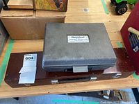 Photo showing the Fleet Check Ultrasonic Leak Detector case on top of the wooden Goertz tool case