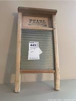 Full view of wooden washboard showing legs, top ledge, and metal scrubbing surface