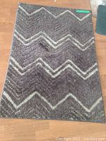 Dark gray rug with chevron pattern in lighter shades
