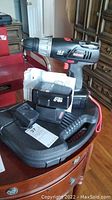 Photo of cordless Craftsman drill with visible model and voltage, two batteries, charger, all resting on plastic carrying case.