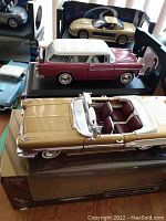Three diecast models displayed together: gold Corvette convertible at front, burgundy and white Nomad in middle, silver Bonneville in back