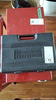Closed black plastic carrying case with Sears Craftsman logo on top.