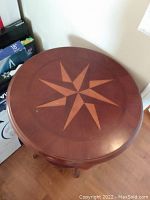 Top view of round end table showing star pattern wood inlay on table surface