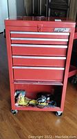 Front view of red Waterloo cabinet showing drawers and lower bin with tools