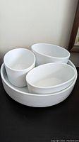 Four piece set of white porcelain serving pieces stacked showing shapes and sizes in use