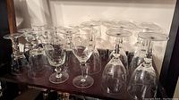 Group photo of 18 glasses arranged in three rows showing all three sizes: liqueur glasses, white wine glasses, and red wine goblets.