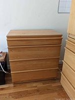 Low dresser with flat top and three drawers, natural light oak wood finish, no visible hardware.