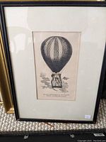 Full view of framed hot air balloon illustration showing the entire frame and matting.