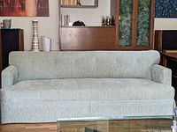 Front view of Mid-Century Modern sofa in sage green chenille upholstery showing clean lines and tailored skirt.
