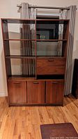Full view of the tall mid-century modern wood bookcase/room divider showing open shelving upper section and cabinet doors below.