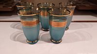 Photo showing all five blue and gold glasses arranged on a surface
