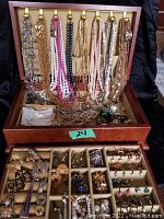 Full view of wood jewelry box open showing hanging chains and organized jewelry below