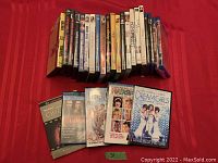 Photo showing the collection of 26 DVD cases arranged on red fabric with titles including Dream Girls, Chicago, La Mome, Harsh Times visible.