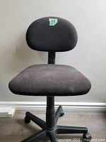 Front view of the office chair showing cushioned seat and backrest in dark brown fabric.