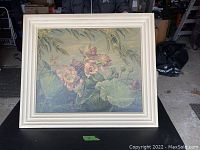 Full image of framed vintage water lilies picture on black surface.