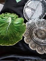 Photo showing all three dishes together: green cabbage leaf dish, large clear glass divided dish with ornate patterns, smaller clear glass divided dish.