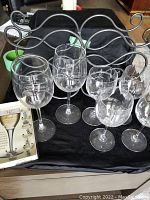Front view showing 4 crystal wine glasses, 2 spiral design glasses, metal wine rack, and wine glass charm packaging