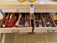 Top view of three kitchen drawers with assorted cooking utensils, knives, forks, and small kitchen tools in wooden and plastic dividers, needing cleaning.