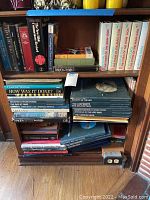 Shelf view showing assorted hardbound books in dust jackets and slipcases