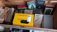 Photo of vintage books including Visualized Physics, Fundamentals of Air Fighting and Ground Instructor's Manual alongside Kodak carousel box with slide projector inside.