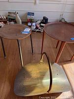 Two round tables side by side with brass log carrier in front