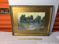 Frontal image of the framed watercolor showing the country house and surrounding trees with gold ornate frame and textured gold mat.
