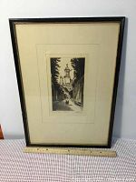 Full view of the framed etching showing the black frame and white mat with visible ruler for size context.