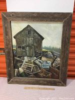 Full view of the oil painting depicting a rustic fishing shack and crab traps with barn board frame.