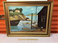 Full frontal view of the framed oil on board painting showing sailboats docked in a harbour with landscape background.