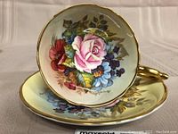 Front view of teacup resting on saucer showing overall appearance and matching floral interior