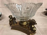 Front view of crystal bowl on gilt base with cherubs