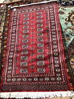 Full view of the red Persian style area carpet laid flat